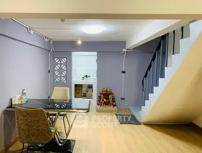Modern living room with sleek staircase and stylish dining area