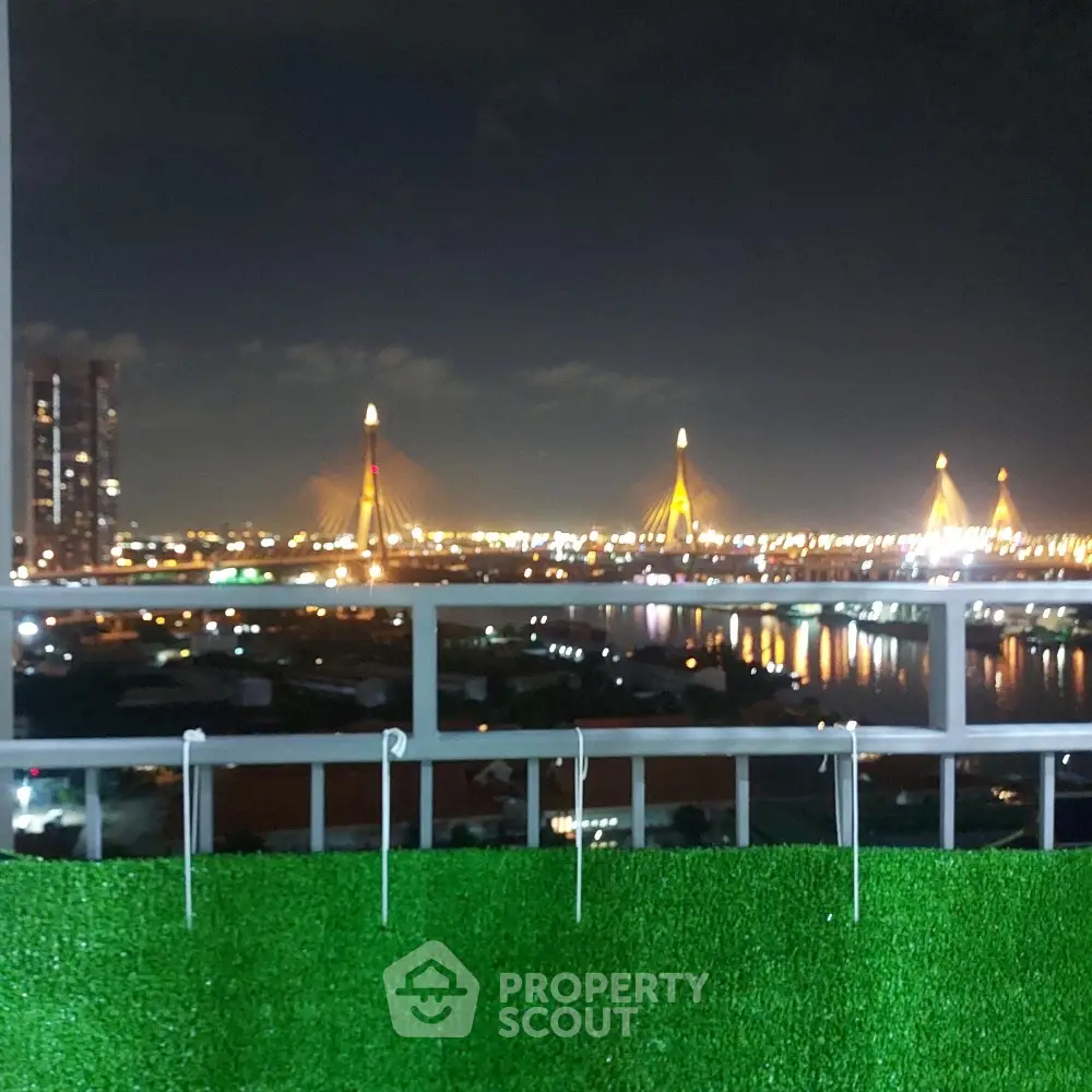 Stunning night view from balcony overlooking illuminated cityscape and river