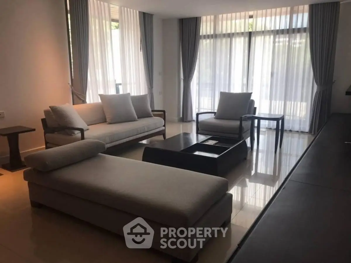 Spacious modern living room with elegant furniture and large windows.