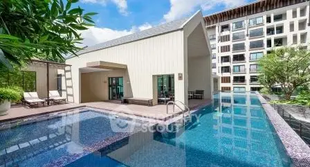 Luxurious modern apartment complex with stunning outdoor pool and lush greenery.
