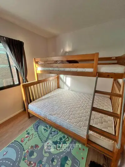 Cozy bedroom with bunk bed and playful rug, perfect for kids.