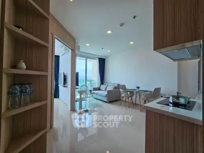 Modern open-plan living room with sleek kitchen and stunning city view.