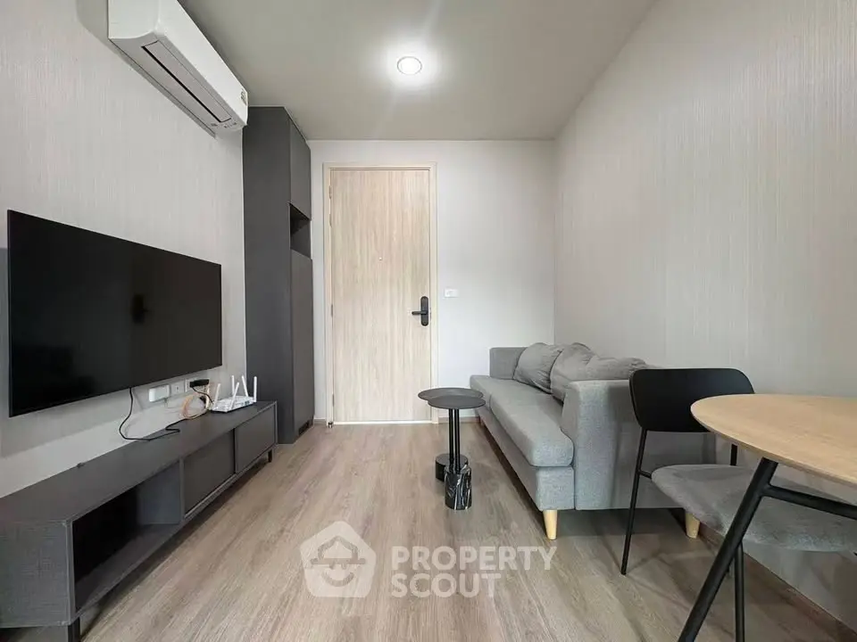 Modern living room with sleek furniture and wall-mounted TV in a stylish apartment.