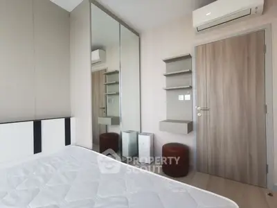 Modern bedroom with mirrored wardrobe and air conditioning unit
