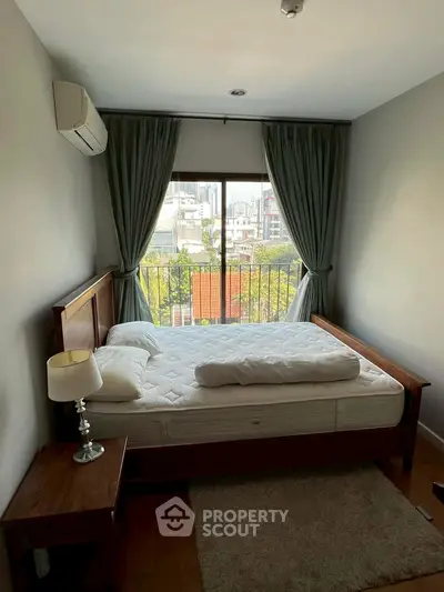 Cozy bedroom with city view, featuring a comfortable bed and elegant decor, perfect for relaxation.