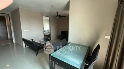 Modern living room with sleek furniture and glass dining table in a contemporary apartment.
