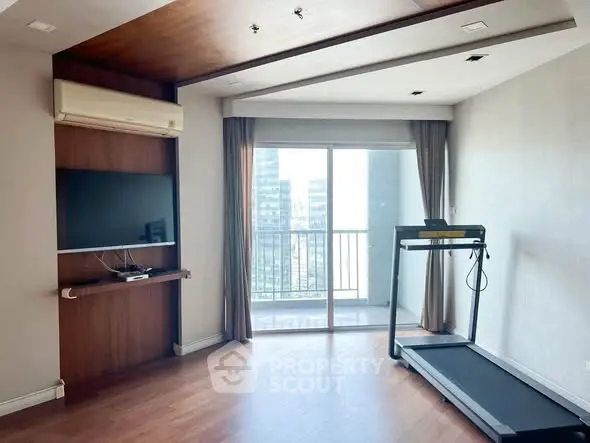 Modern living room with treadmill and balcony view in high-rise apartment.