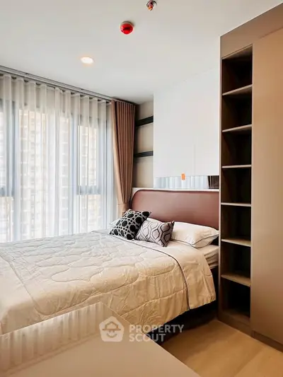 Modern bedroom with stylish decor and large windows in a high-rise apartment.