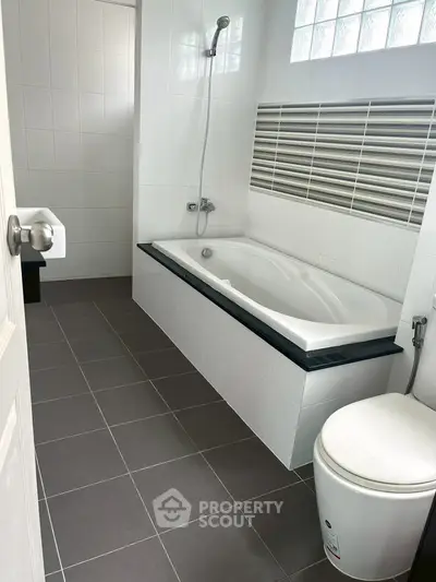Modern bathroom with sleek bathtub and contemporary tile design.