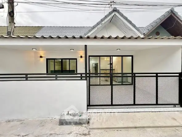 Charming single-story home with modern facade and secure gated entrance.