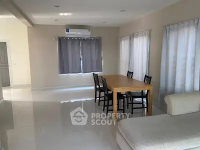 Spacious living room with modern dining area and natural light