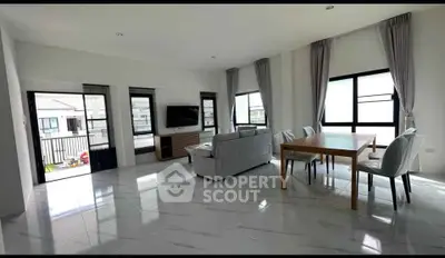Spacious modern living room with large windows and elegant dining area