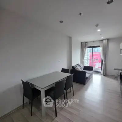 Modern living room with dining area and balcony view in a stylish apartment.