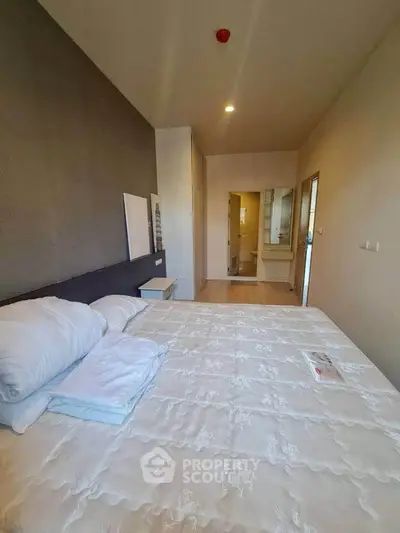 Spacious bedroom with modern decor and ensuite bathroom in a stylish apartment.