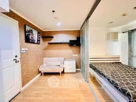 Modern studio apartment with cozy living area and stylish bedroom separated by glass partition.