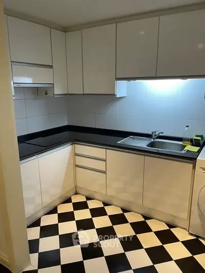Modern kitchen with sleek white cabinets and black countertops