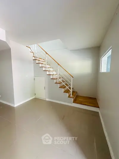 Modern minimalist staircase in bright open space with glossy tile flooring