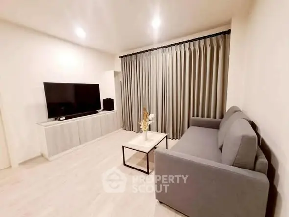 Modern living room with sleek furniture and large TV, perfect for relaxation and entertainment.