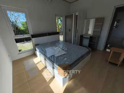 Bright bedroom with large windows and modern furniture, perfect for relaxation.