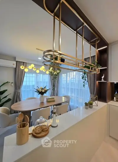 Luxurious modern kitchen with elegant dining area and stylish lighting fixtures.