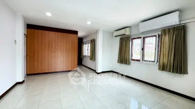 Spacious living room with tiled flooring and air conditioning in modern apartment.