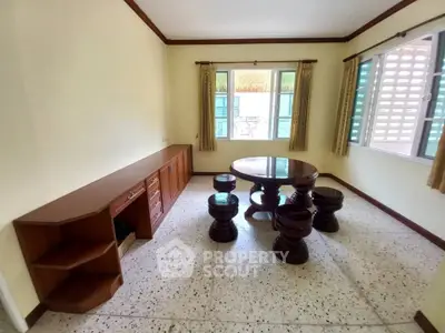 Charming living room with unique wooden furniture and ample natural light.