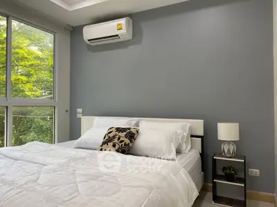 Modern bedroom with large window and air conditioning, featuring stylish decor and natural light.