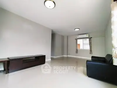 Spacious minimalist living room with modern lighting and sleek flooring.