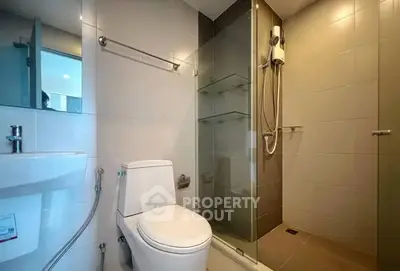 Modern bathroom with glass shower and sleek fixtures in a contemporary home.