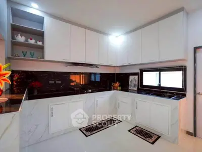 Modern kitchen with sleek white cabinets and black marble backsplash
