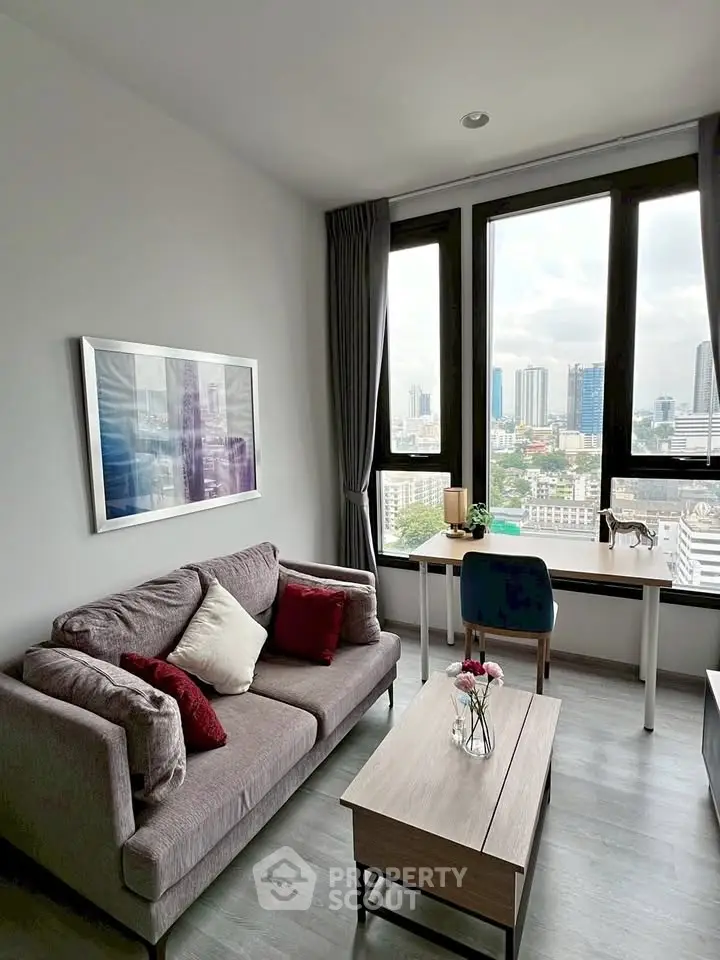 Modern living room with city view, stylish furniture, and large windows in a high-rise apartment.