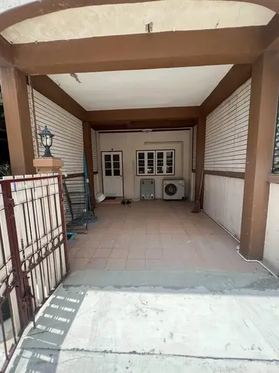 Charming covered patio with tiled flooring and wooden accents, perfect for outdoor relaxation or storage.