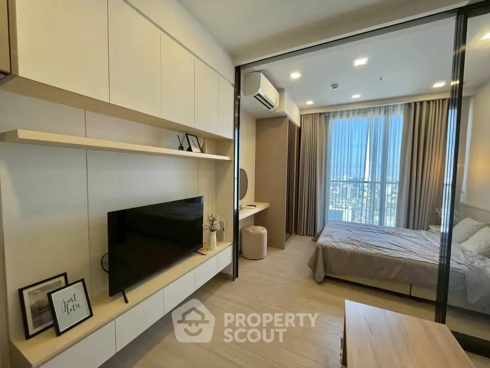 Modern bedroom with sleek design and city view, featuring built-in storage and large windows.