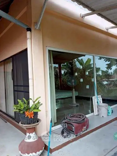 Charming patio with sliding glass doors and lush greenery, perfect for relaxation and outdoor enjoyment.