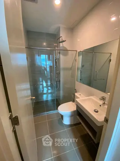 Modern bathroom with glass shower and sleek fixtures in a contemporary home.