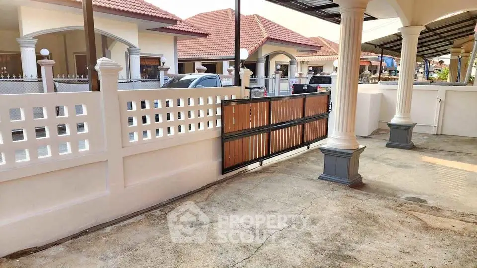 Charming suburban home with spacious driveway and elegant gated entrance.