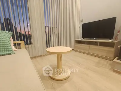 Modern living room with sleek furniture and large windows offering a stunning sunset view.