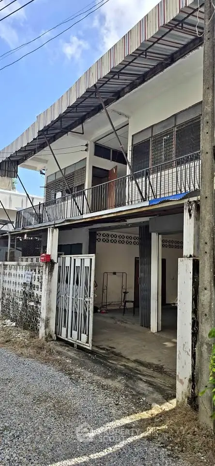 Charming two-story house with gated entrance and spacious balcony, perfect for family living.