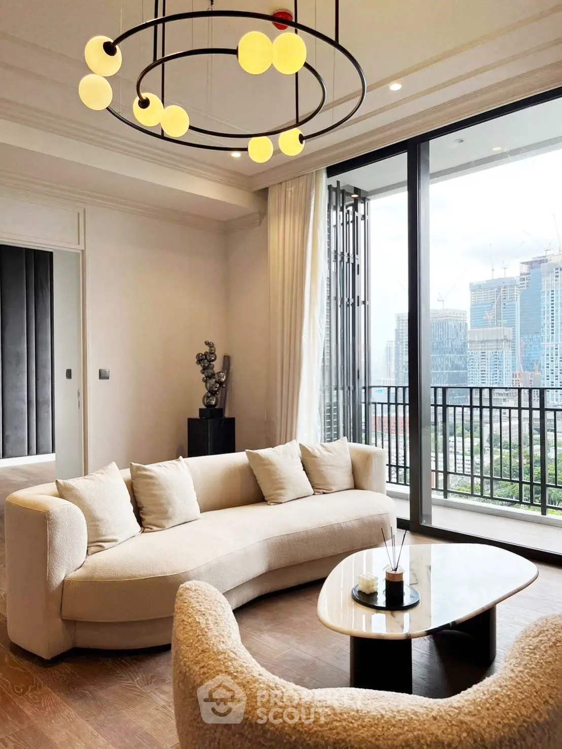 Luxurious living room with modern decor and stunning city view from large balcony.