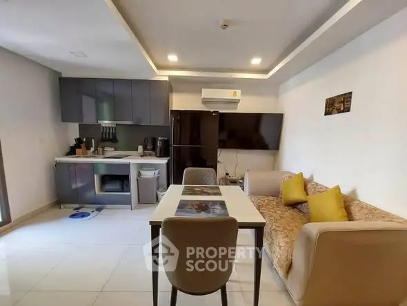 Modern open-layout kitchen and living area with sleek design and cozy seating.