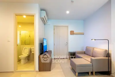 Modern living room with cozy sofa and open view to bathroom, ideal for urban living.
