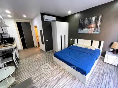 Modern studio apartment with stylish decor and compact kitchen area, perfect for urban living.