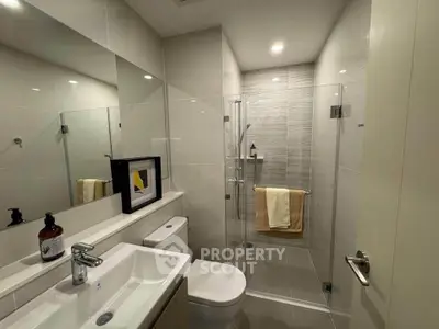 Modern bathroom with glass shower and sleek fixtures in a contemporary apartment.