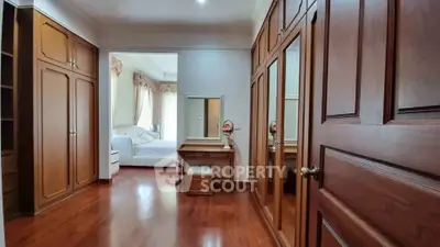 Elegant bedroom with wooden flooring and built-in wardrobes
