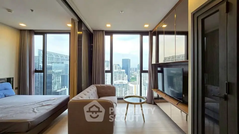 Luxurious high-rise apartment with stunning city view, featuring modern living room and bedroom in open layout.