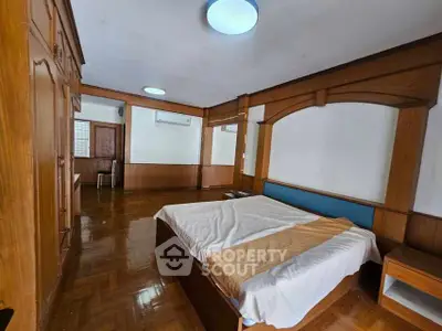 Spacious bedroom with wooden accents and parquet flooring