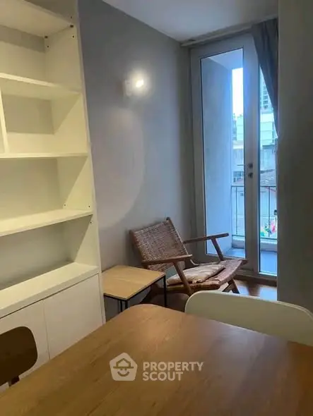 Cozy interior with modern furniture and small balcony access, perfect for urban living.