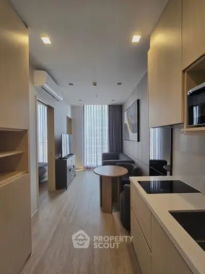 Modern apartment interior with open kitchen and living area, featuring sleek design and natural light.
