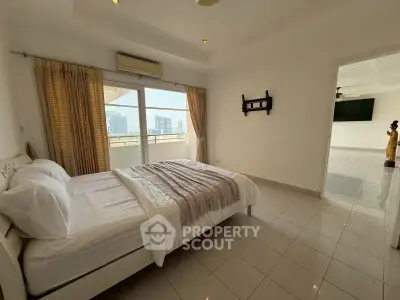 Spacious bedroom with balcony access and city view in modern apartment