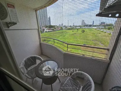 Charming balcony with cozy seating and scenic view of lush green landscape.